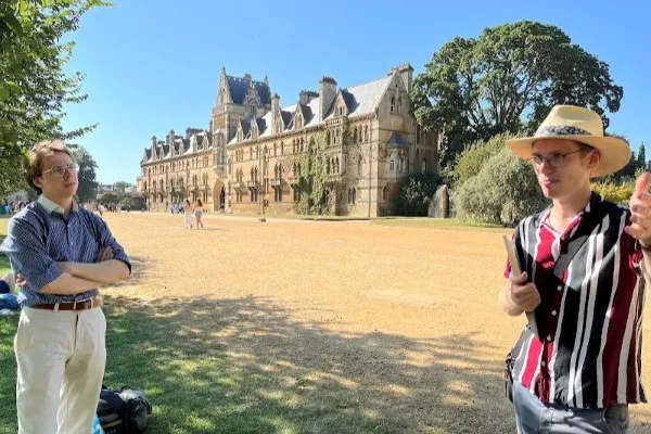 Rory, the tour guide, explains Christ Church and Christ Church Meadow to visitors.